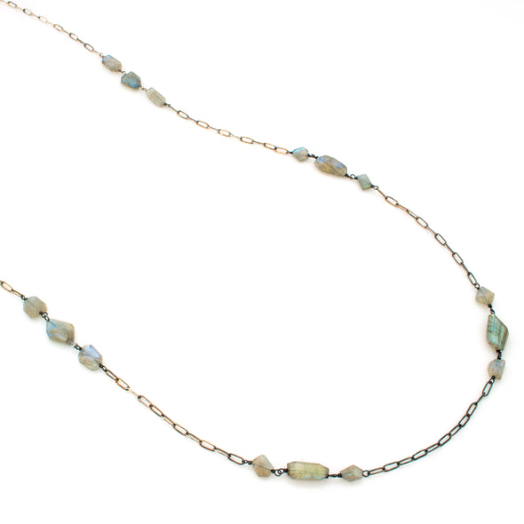 A One-of-a-Kind Necklace featuring Natural Labradorite faceted gemstone beads, set in clusters along an oxidized Sterling silver Chain, handmade by Tribe Jewelry Designer Sarah Lewis.  