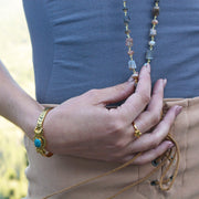 A Long Bohemian Beaded Necklace featuring Faceted Moonstone gemstones on a wire-wrapped chain, paired with an artisanal Gold plated chain, by Tribe Jewelry Designer Sarah Lewis. 