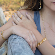 A bohemian style, gold plated stacking ring featuring a tiny star on a hammered band, by Tribe Jewelry Designer Sarah Lewis.