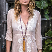 A Bohemian Mala style Necklace featuring a soft Suede Tassel, hanging from a strand of faceted Amethyst gemstone beads, handmade by Tribe Jewelry Designer Sarah Lewis. 