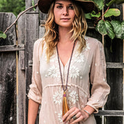 A Bohemian Mala style Necklace featuring a soft Suede Tassel, hanging from a strand of faceted Amethyst gemstone beads, handmade by Tribe Jewelry Designer Sarah Lewis. 