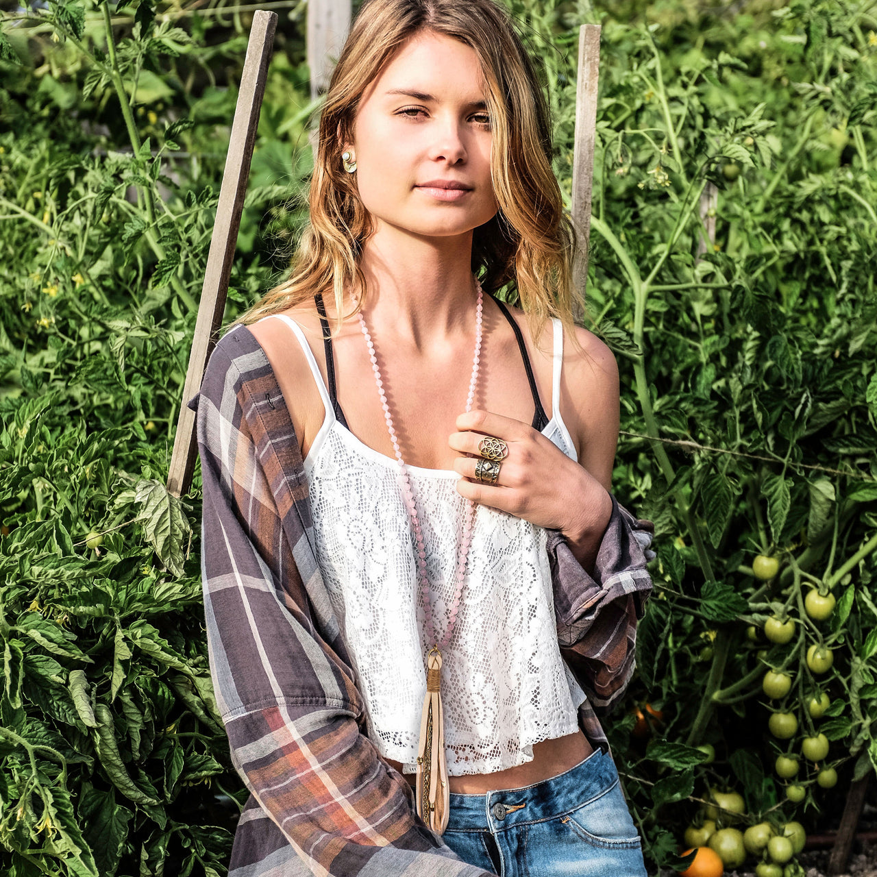 A Bohemian style Mala Necklace featuring a soft Suede Tassel, hanging from a strand of faceted Rose Quartz gemstone beads, handmade by Tribe Jewelry Designer Sarah Lewis. 