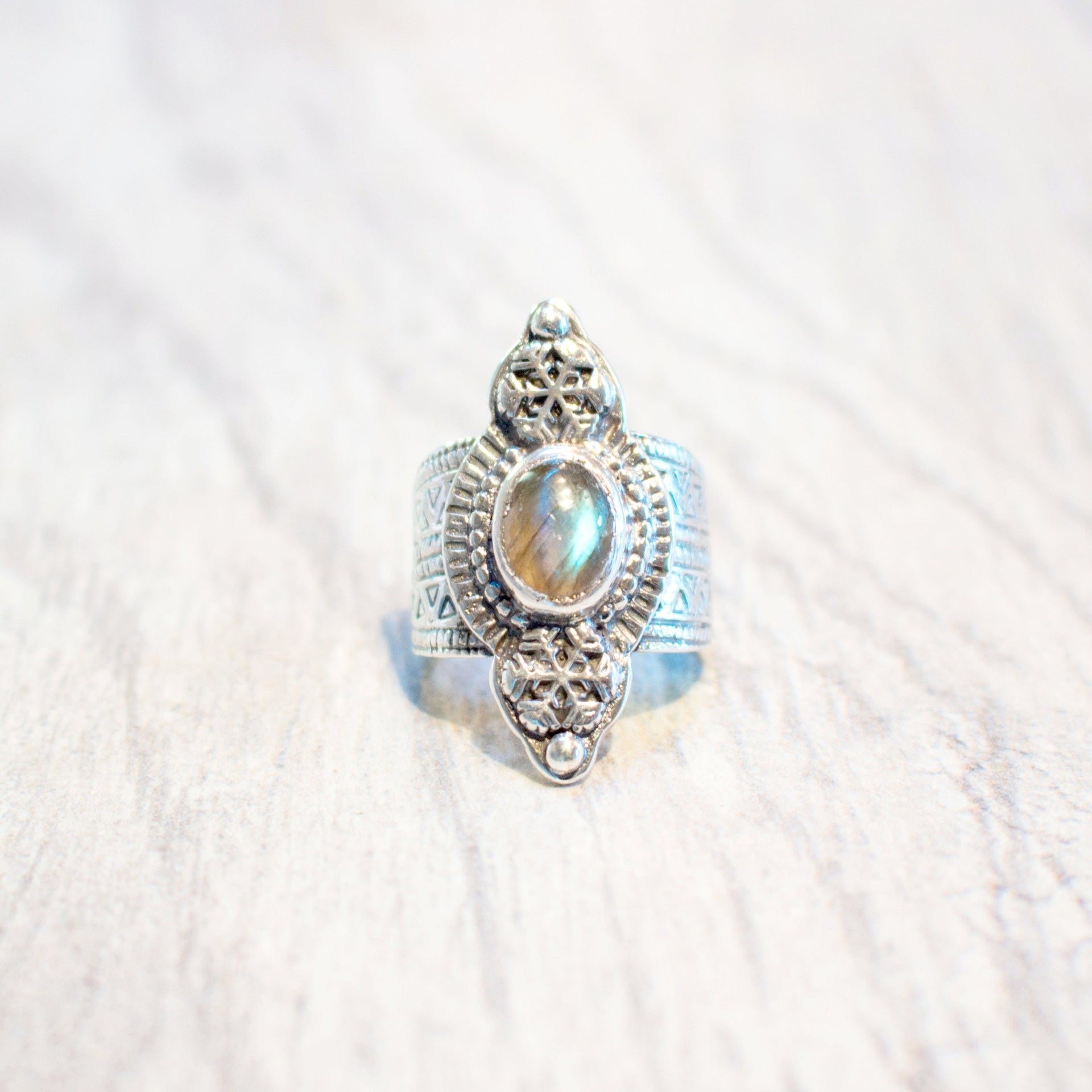 A one of kind ring featuring a faceted labradorite stone set in sterling silver, with snowflake and stamped geometric design handmade by Tribe Jewelry Designer Sarah Lewis.