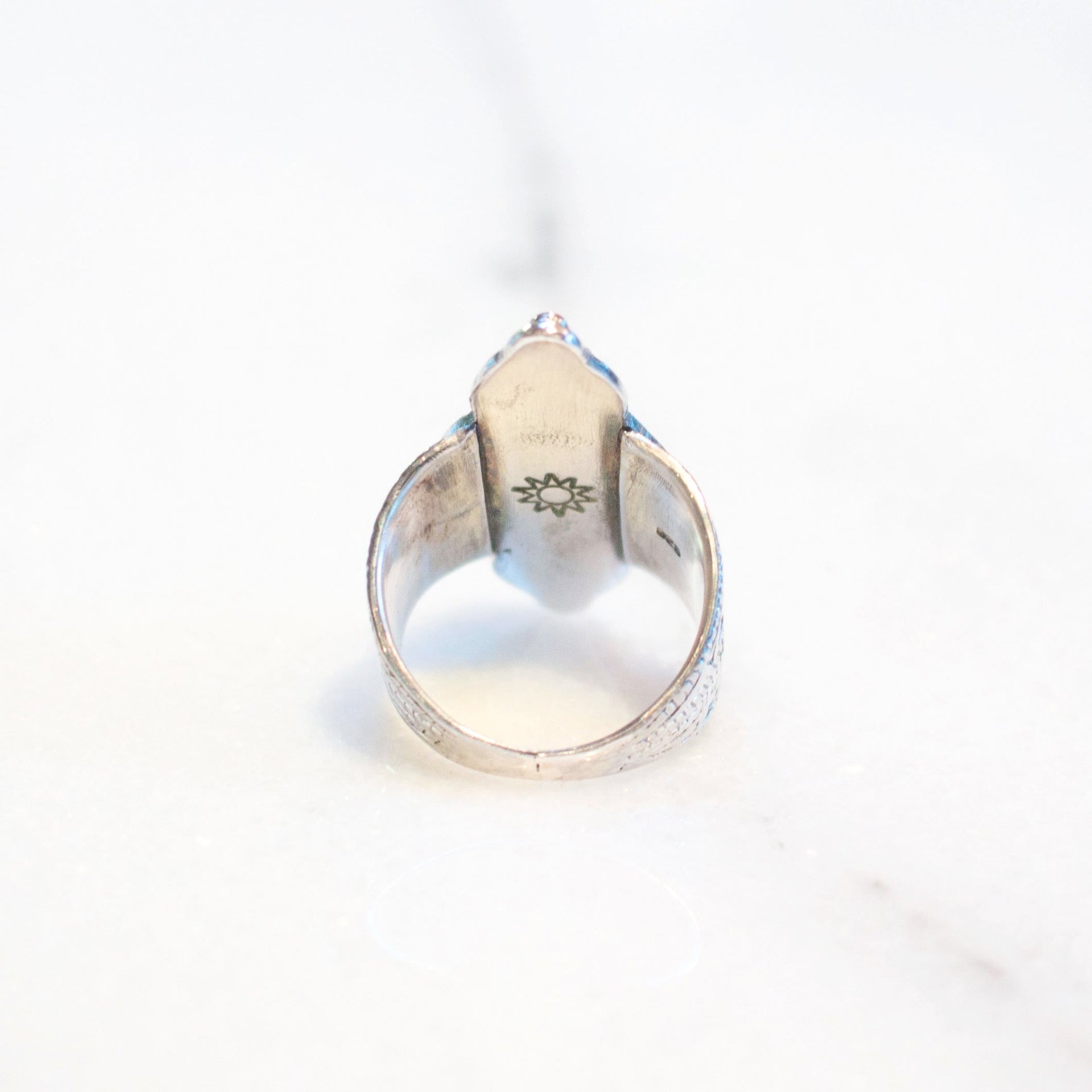 A one of kind ring featuring a faceted labradorite stone set in sterling silver, with snowflake and stamped geometric design handmade by Tribe Jewelry Designer Sarah Lewis.