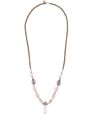 A Quartz Crystal set in engraved Sterling Silver, hangs with natural and cast Cowrie shells, and Silver beads, on a long, Bohemian Statement Necklace, handmade by Tribe Jewelry Designer Sarah Lewis. 