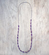A Long Bohemian Beaded Necklace featuring Faceted Amethyst gemstones on a wire-wrapped chain, paired with an artisanal Silver plated chain, handmade by Tribe Jewelry Designer Sarah Lewis. 