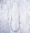 A Long Bohemian Beaded Necklace featuring Faceted Moonstone gemstones on a wire-wrapped chain, paired with an artisanal Gold plated chain, by Tribe Jewelry Designer Sarah Lewis. 