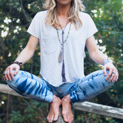 A Bohemian style Lariat Necklace, featuring 2 cotton tassels hanging from a long strand of natural, faceted amethyst stone beads, by Tribe Jewelry Designer Sarah Lewis. 