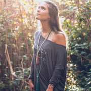 A Bohemian style Lariat Necklace, featuring 2 tassels hanging from a long strand of natural, faceted turquoise stone beads, by Tribe Jewelry Designer Sarah Lewis. 