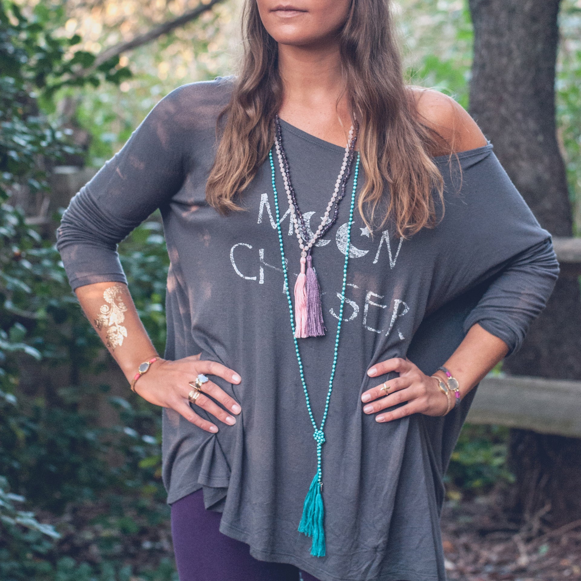 A Bohemian style Lariat Necklace, featuring 2 tassels hanging from a long strand of natural, faceted turquoise stone beads, by Tribe Jewelry Designer Sarah Lewis. 