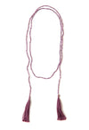 A Bohemian style Lariat Necklace, featuring 2 cotton tassels hanging from a long strand of natural, faceted amethyst stone beads, by Tribe Jewelry Designer Sarah Lewis. 
