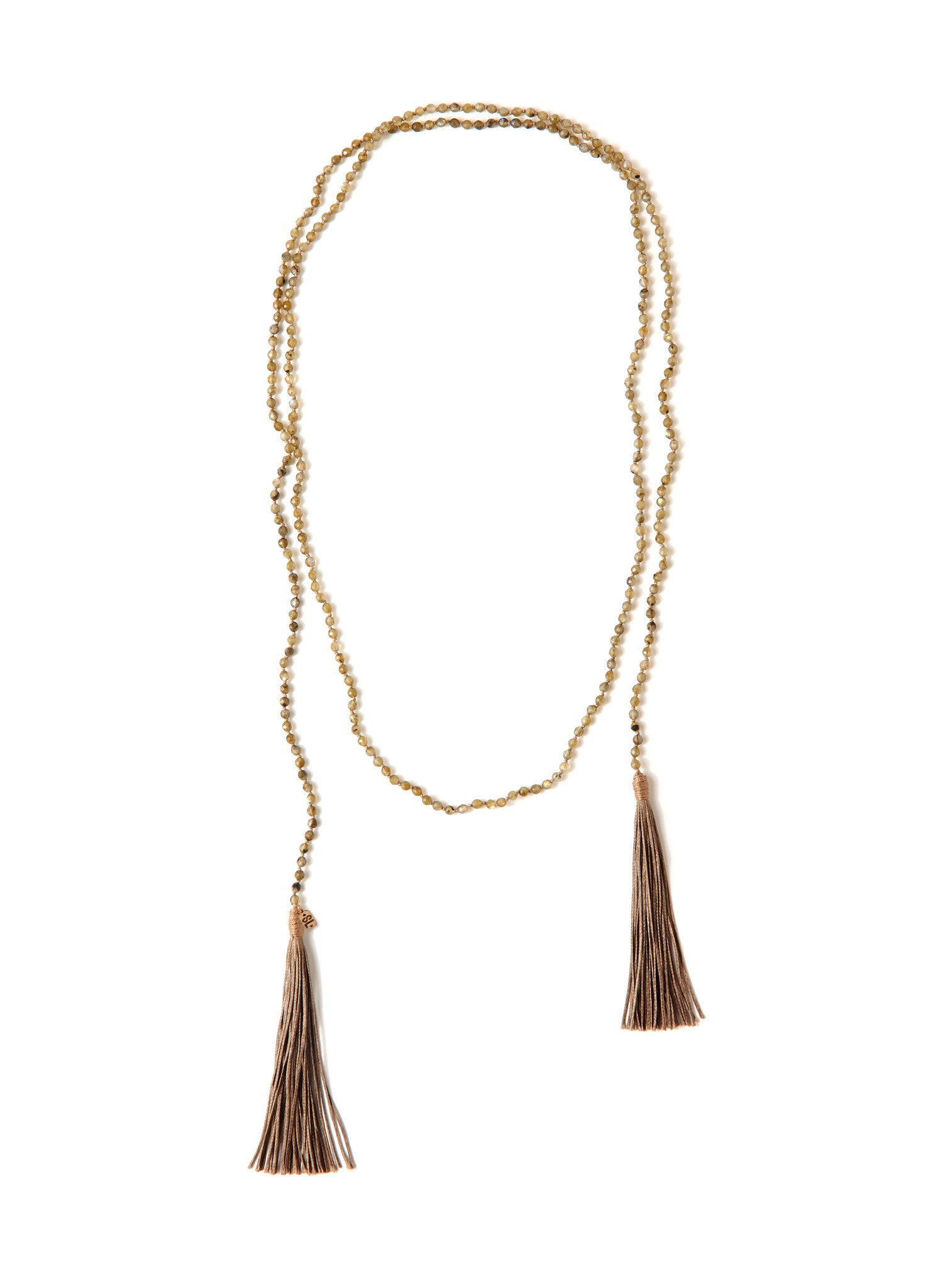 A Bohemian style Lariat Necklace, featuring 2 cotton tassels hanging from a long strand of natural, faceted labradorite stone beads, by Tribe Jewelry Designer Sarah Lewis. 