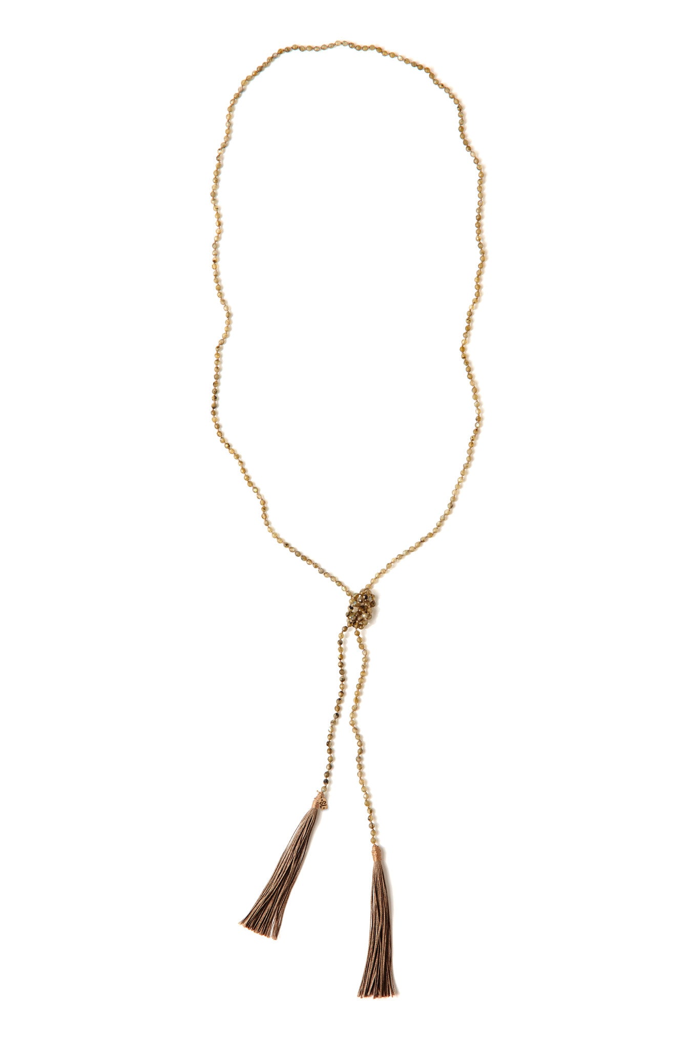 A Bohemian style Lariat Necklace, featuring 2 cotton tassels hanging from a long strand of natural, faceted labradorite stone beads, by Tribe Jewelry Designer Sarah Lewis. 