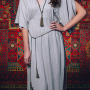 A Bohemian style Lariat Necklace, featuring 2 cotton tassels hanging from a long strand of natural, faceted labradorite stone beads, by Tribe Jewelry Designer Sarah Lewis. 