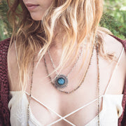 A Bohemian style Lariat Necklace, featuring 2 cotton tassels hanging from a long strand of natural, faceted labradorite stone beads, by Tribe Jewelry Designer Sarah Lewis. 