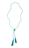 A Bohemian style Lariat Necklace, featuring 2 tassels hanging from a long strand of natural, faceted turquoise stone beads, by Tribe Jewelry Designer Sarah Lewis. 