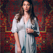 A Bohemian style Lariat Necklace, featuring 2 tassels hanging from a long strand of natural, faceted turquoise stone beads, by Tribe Jewelry Designer Sarah Lewis. 